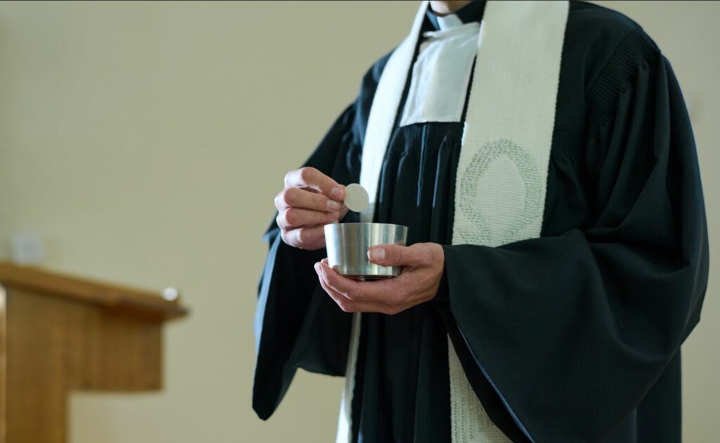 padre distribuindo o sacramento da eucaristia