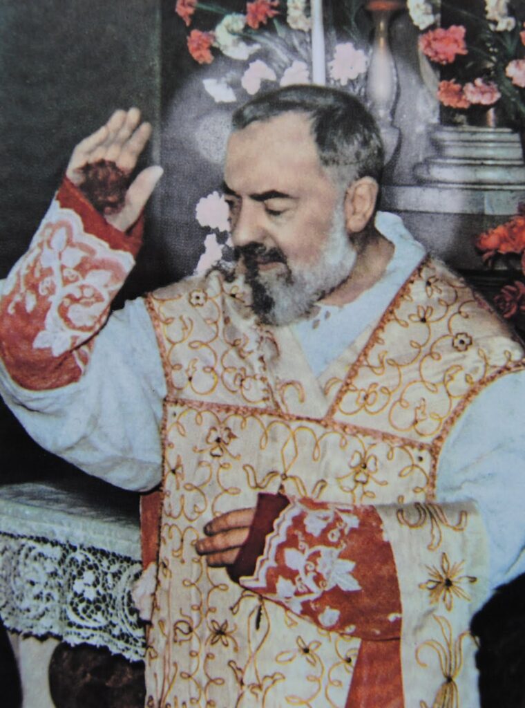 imagem do Padre Pio abençoando os fiéis com os estigmas aparentes.
