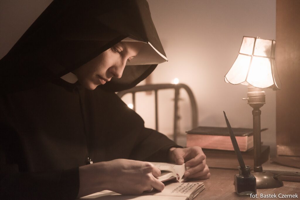 reprodução da imagem de Santa Faustina escrevendo em seu diário.