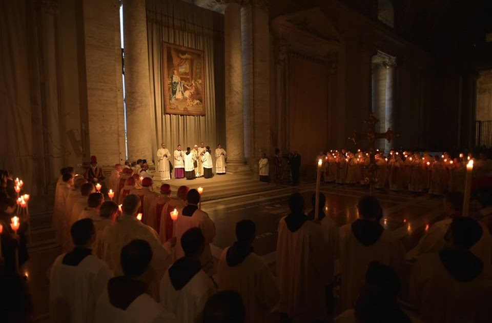 pessoas com velas acesas numa igreja escura, uma tradição da festa da apresentação do senhor. 