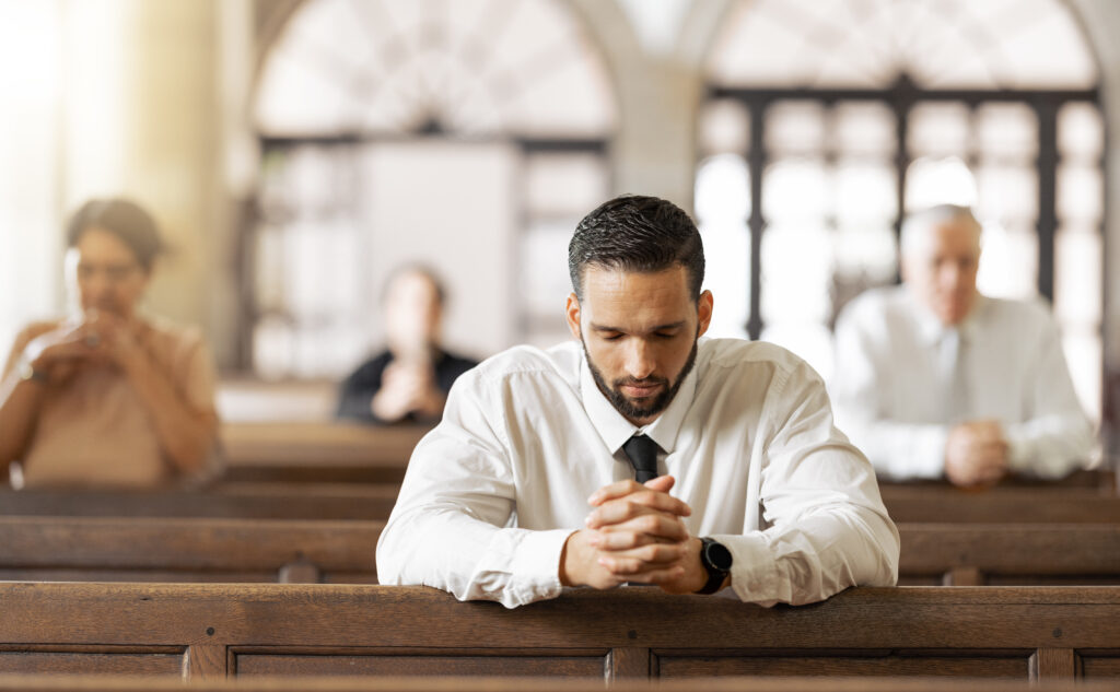 homem rezando de joelhos na igreja, algo que pode ser intensificado como forma de penitência. 